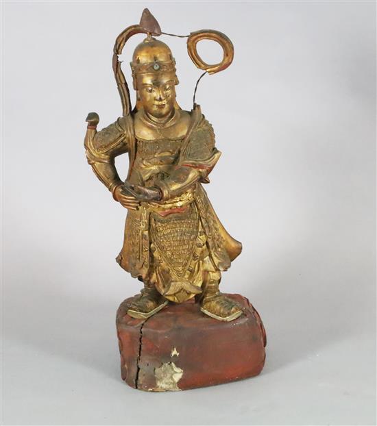A large Chinese gilt-decorated and polychrome lacquer figure of a temple guardian, 19th century, H.75cm, losses